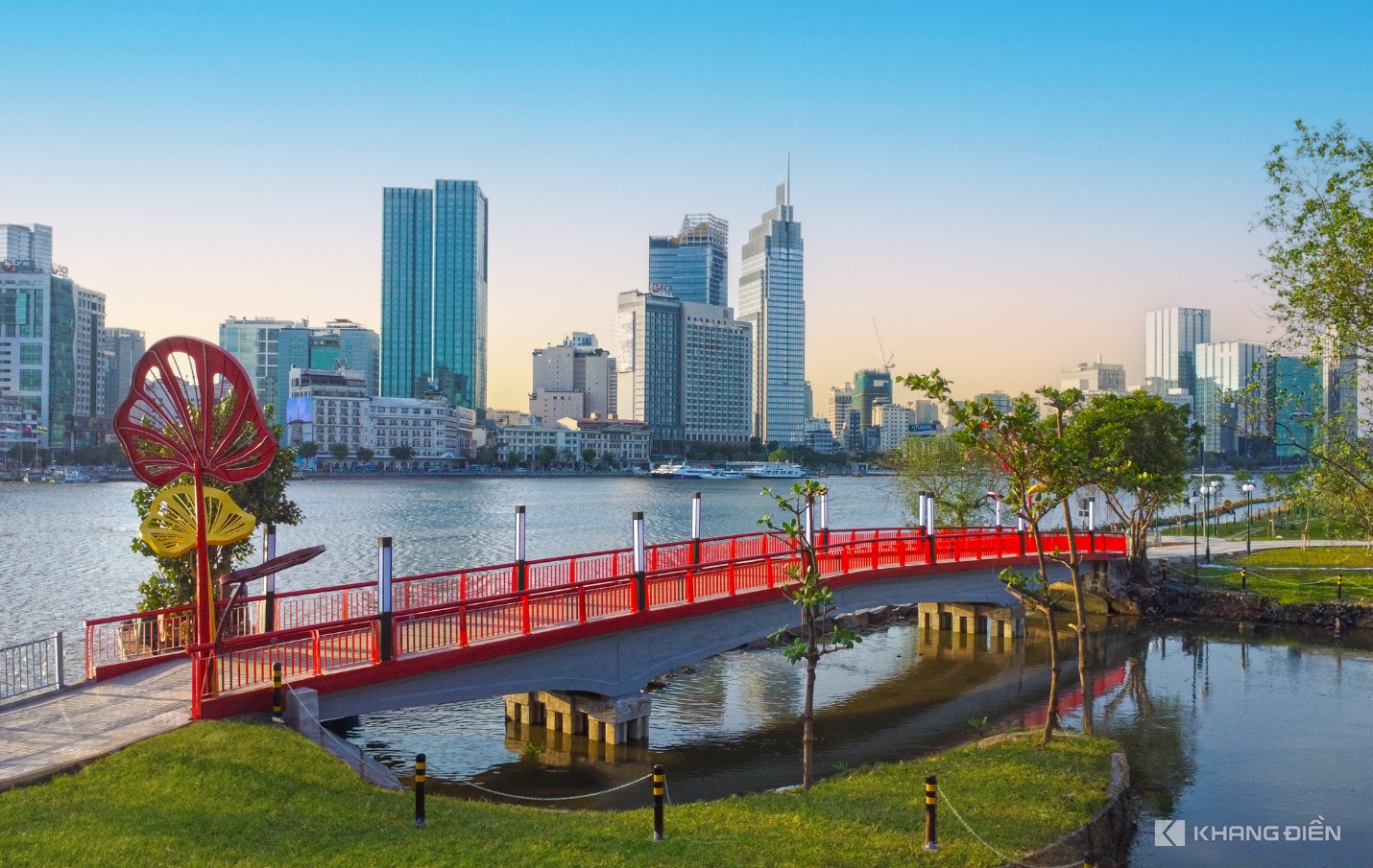 A bridge over water with a city in the background Description automatically generated