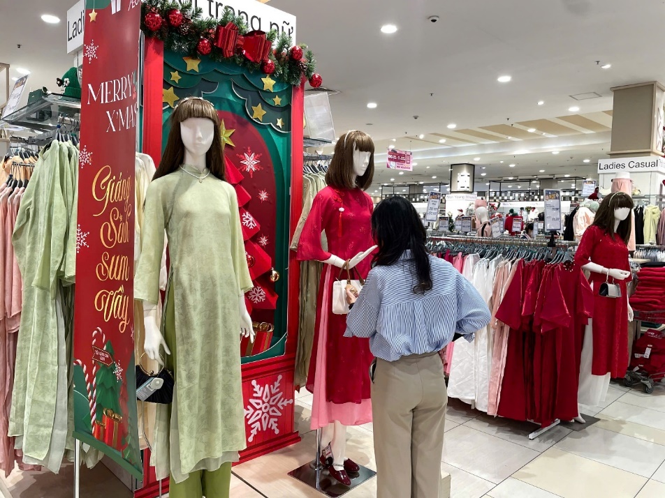 A person standing in front of a store with mannequins Description automatically generated