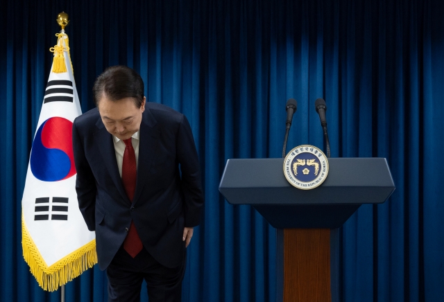 President Yoon Suk Yeol bows to the public to wrap up his televised address to the nation in his office in Seoul on Saturday. (Presidential office)
