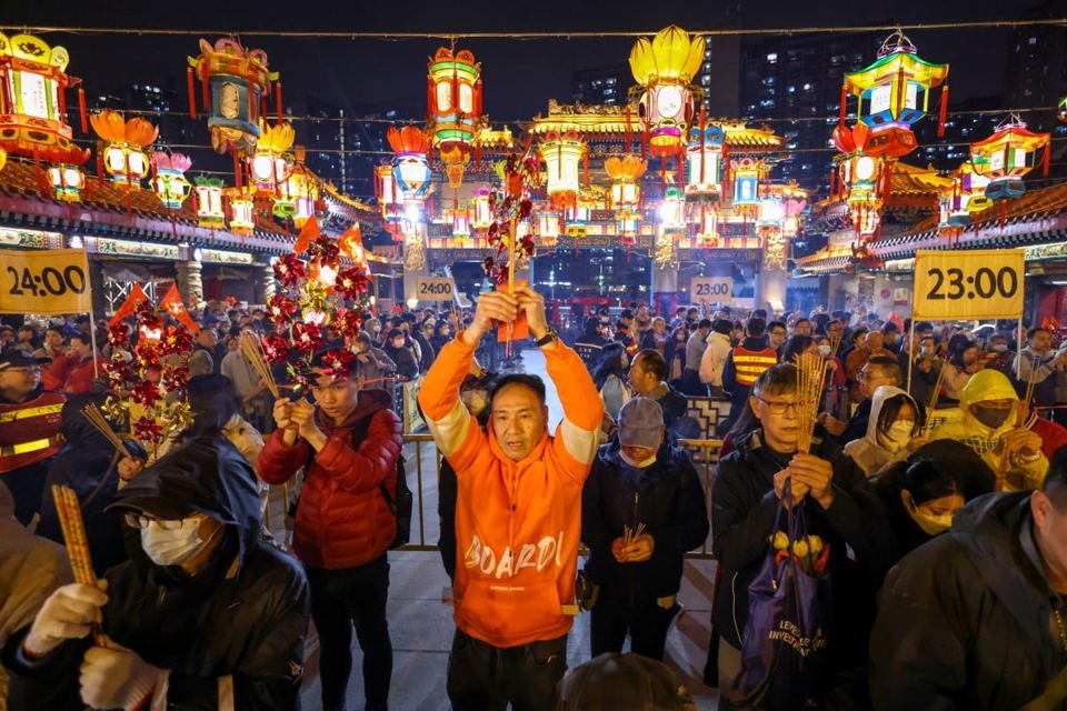 Những người thờ c&uacute;ng d&acirc;ng hương đầu ti&ecirc;n tại Đền thờ Huỳnh Đại Ti&ecirc;n v&agrave;o đ&ecirc;m giao thừa như một phần của lễ hội ch&agrave;o đ&oacute;n năm Gi&aacute;p Th&igrave;n. Ảnh: SCMP