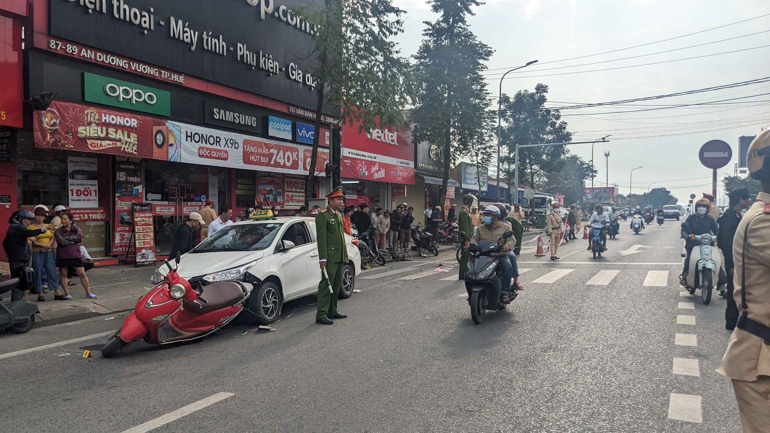 Xe taxi t&ocirc;ng nhiều xe m&aacute;y, xe đạp ở giao lộ c&oacute; đ&egrave;n đỏ- Ảnh 2.