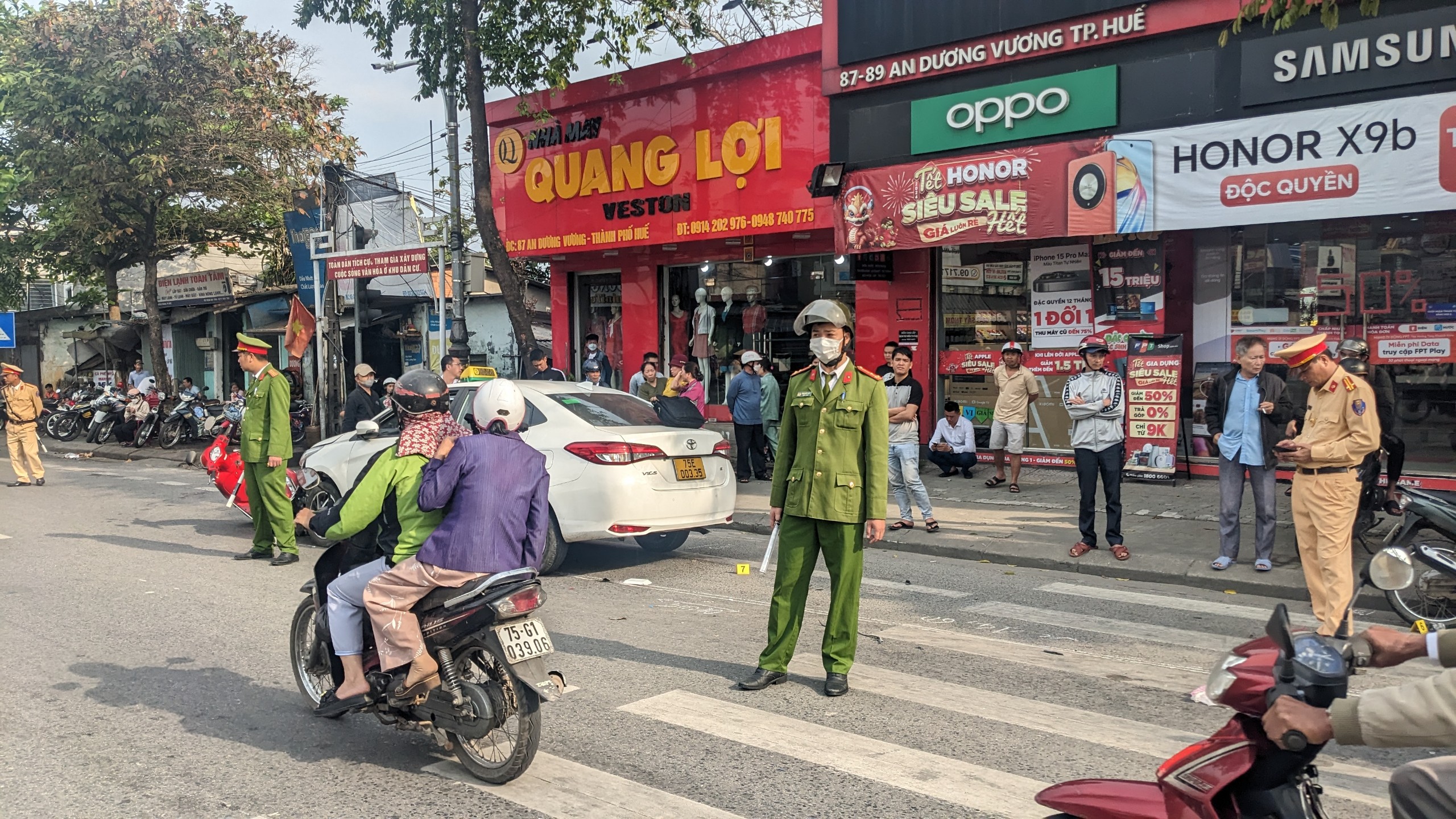 Xe taxi t&ocirc;ng nhiều xe m&aacute;y, xe đạp ở giao lộ c&oacute; đ&egrave;n đỏ- Ảnh 1.