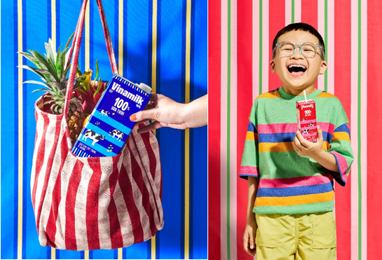 A child holding a box of juice Description automatically generated