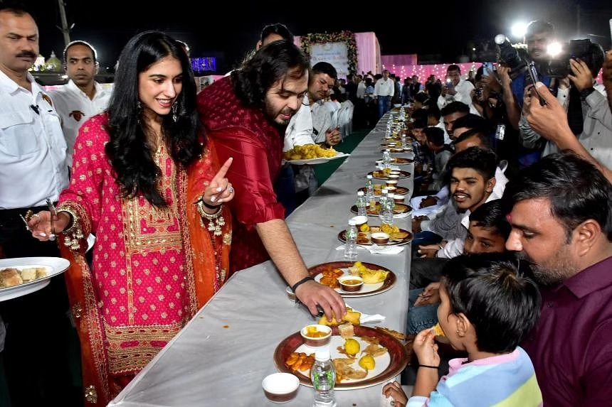 Anant Ambani v&agrave; vợ sắp cưới phục vụ m&oacute;n ăn truyền thống cho d&acirc;n l&agrave;ng. Ảnh: Reuters