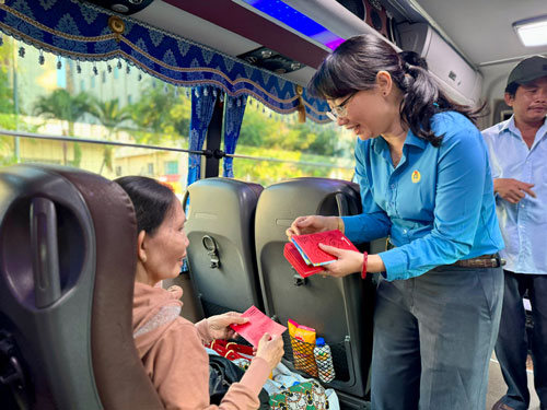 B&agrave; Trần Thị Diệu Th&uacute;y, Chủ tịch LĐLĐ TP HCM, l&igrave; x&igrave; cho đo&agrave;n vi&ecirc;n nghiệp đo&agrave;n về qu&ecirc; đ&oacute;n Tết trong chương tr&igrave;nh &ldquo;Chuyến xe m&ugrave;a xu&acirc;n&rdquo;.Ảnh: HUỲNH NHƯ