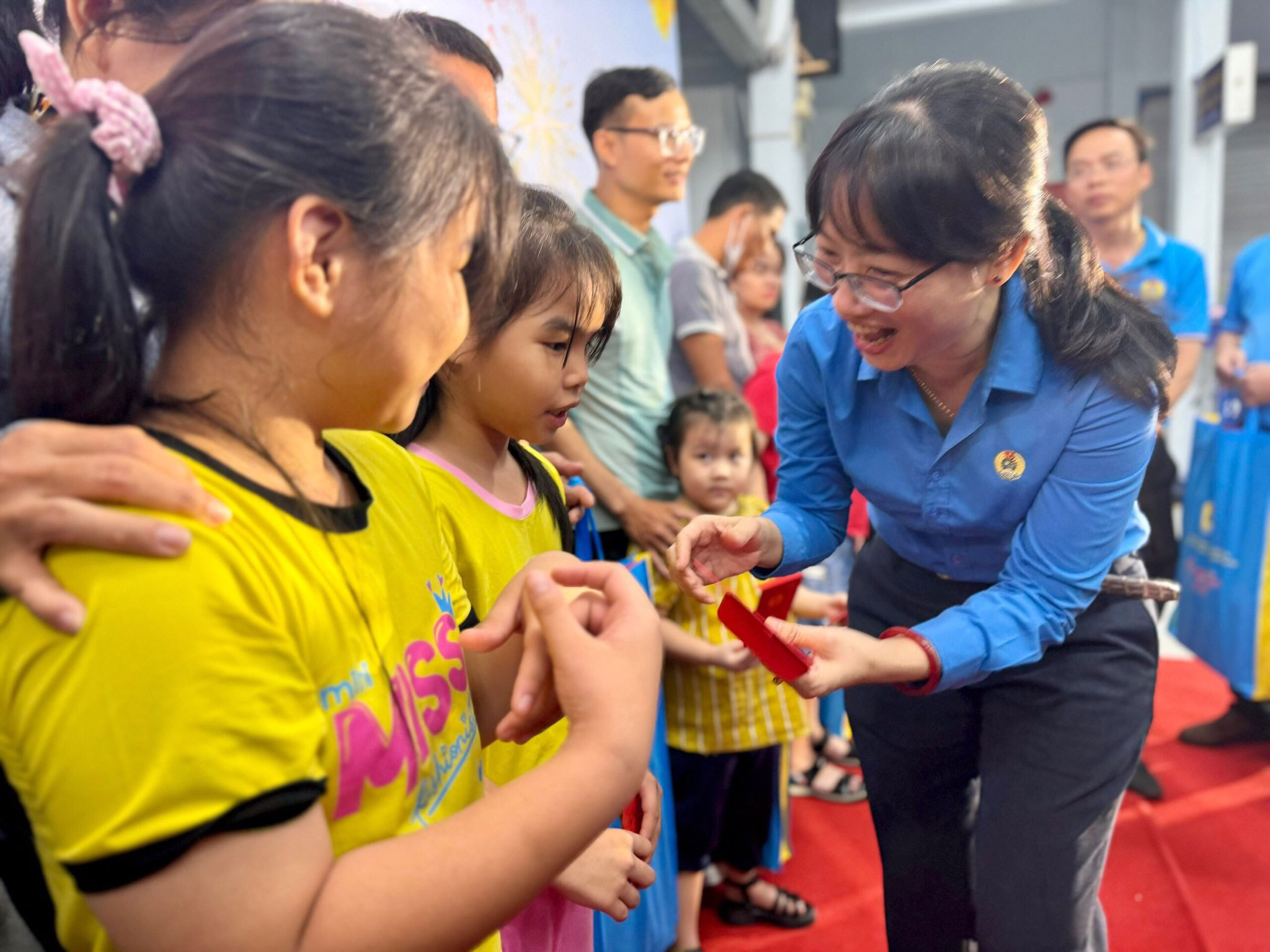 B&agrave; Trần Thị Diệu Th&uacute;y, Chủ tịch LĐLĐ TP HCM, l&igrave; x&igrave; cho con đo&agrave;n vi&ecirc;n kh&oacute; khăn trong chương tr&igrave;nh &ldquo;Chuyến t&agrave;u m&ugrave;a xu&acirc;n&ldquo; Ảnh: HUỲNH NHƯ