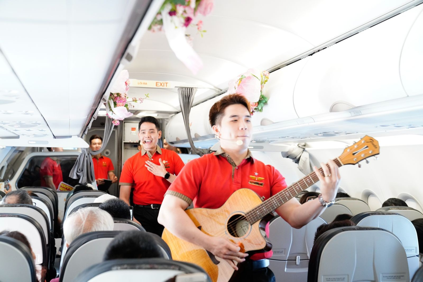 A person playing a guitar on an airplane  Description automatically generated