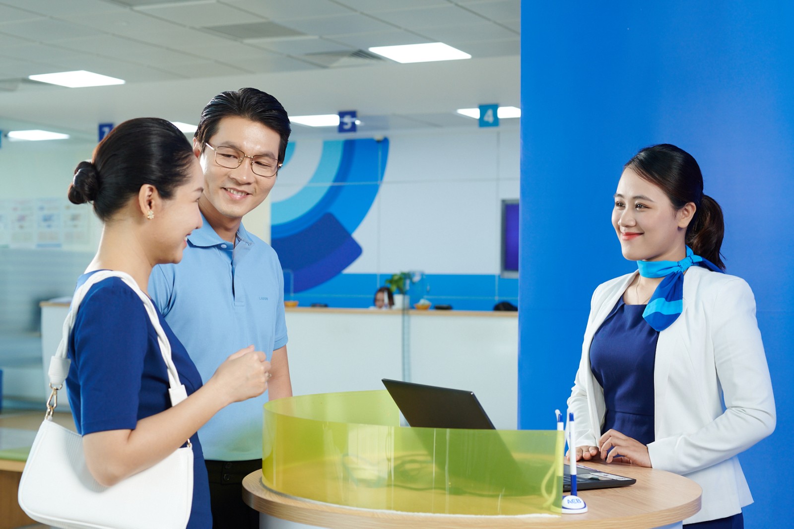 A group of people standing around a desk  Description automatically generated