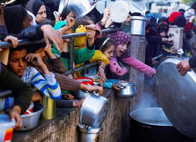 Người d&acirc;n Palestine chờ nhận thực phẩm tại TP Rafah ở Gaza. Ảnh: Reuters
