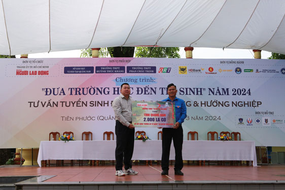 &Ocirc;ng Đặng Ho&agrave;ng Dũng, Trưởng Văn ph&ograve;ng đại diện B&aacute;o Người Lao Động khu vực miền Trung (tr&aacute;i), trao bảng tượng trưng 2.000 l&aacute; cờ Tổ quốc cho Huyện Đo&agrave;n Ti&ecirc;n Phước  Ảnh: HẢI ĐỊNH
