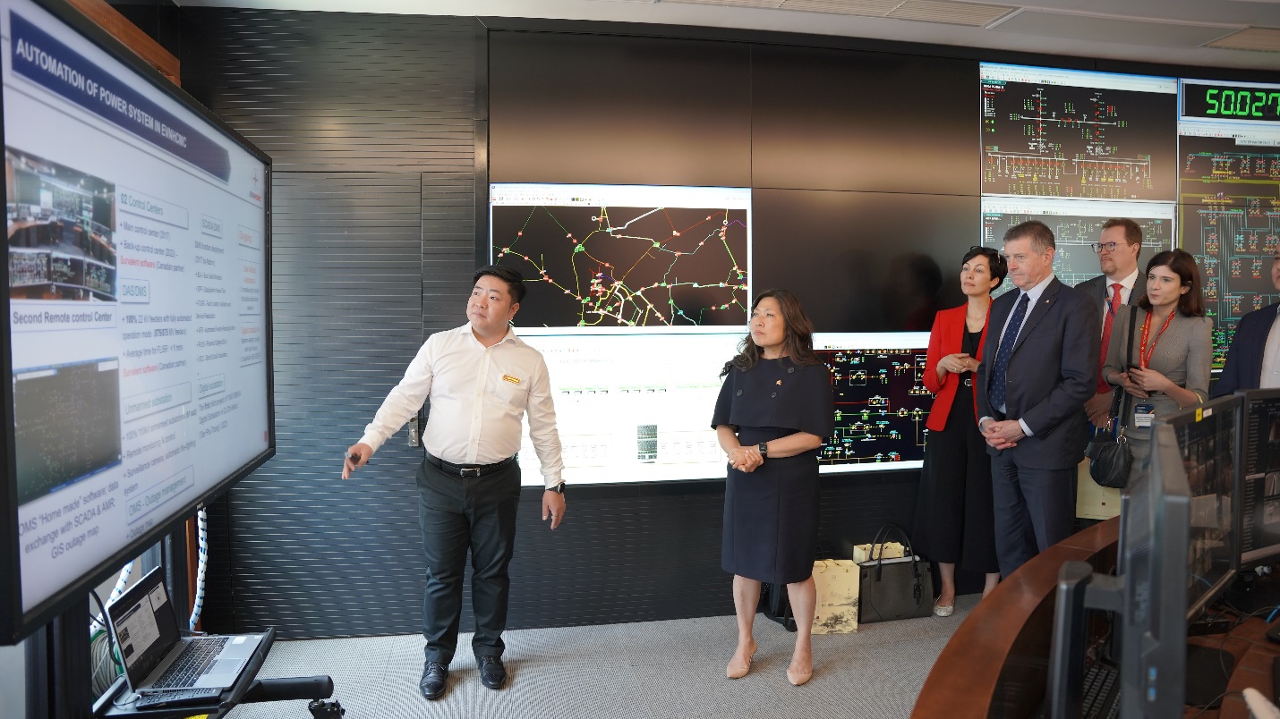 A group of people standing in front of a screen  Description automatically generated