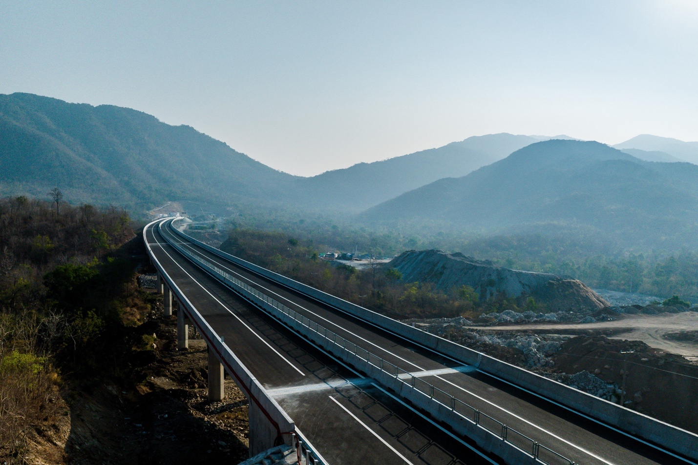 A highway with a mountain in the background Description automatically generated