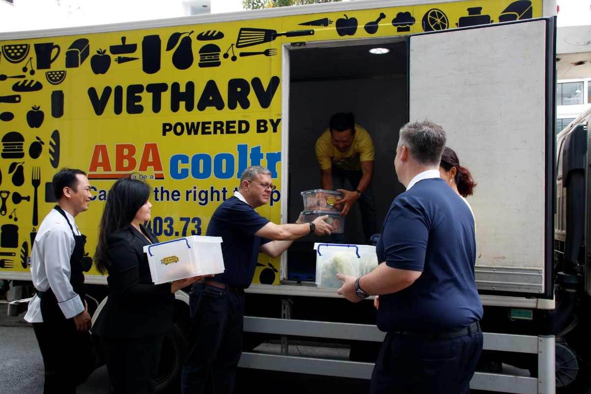 A group of people standing in a truck  Description automatically generated