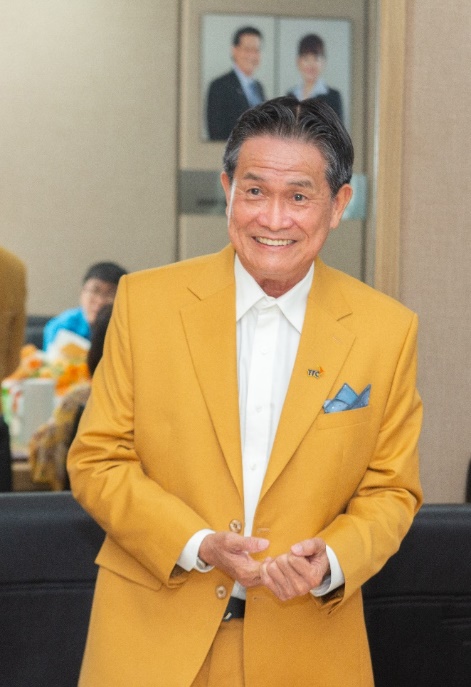A person in a yellow suit Description automatically generated