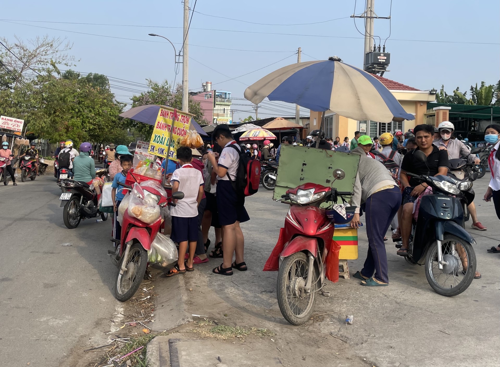Rất đ&ocirc;ng trẻ nhỏ mua đồ ăn b&agrave;y b&aacute;n trước cổng trường