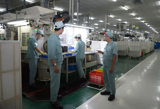 Anh Phạm Văn Phương (b&igrave;a phải) trao đổi c&ocirc;ng việc với c&ocirc;ng nh&acirc;n tổ sản xuất. (Ảnh do nh&acirc;n vật cung cấp)