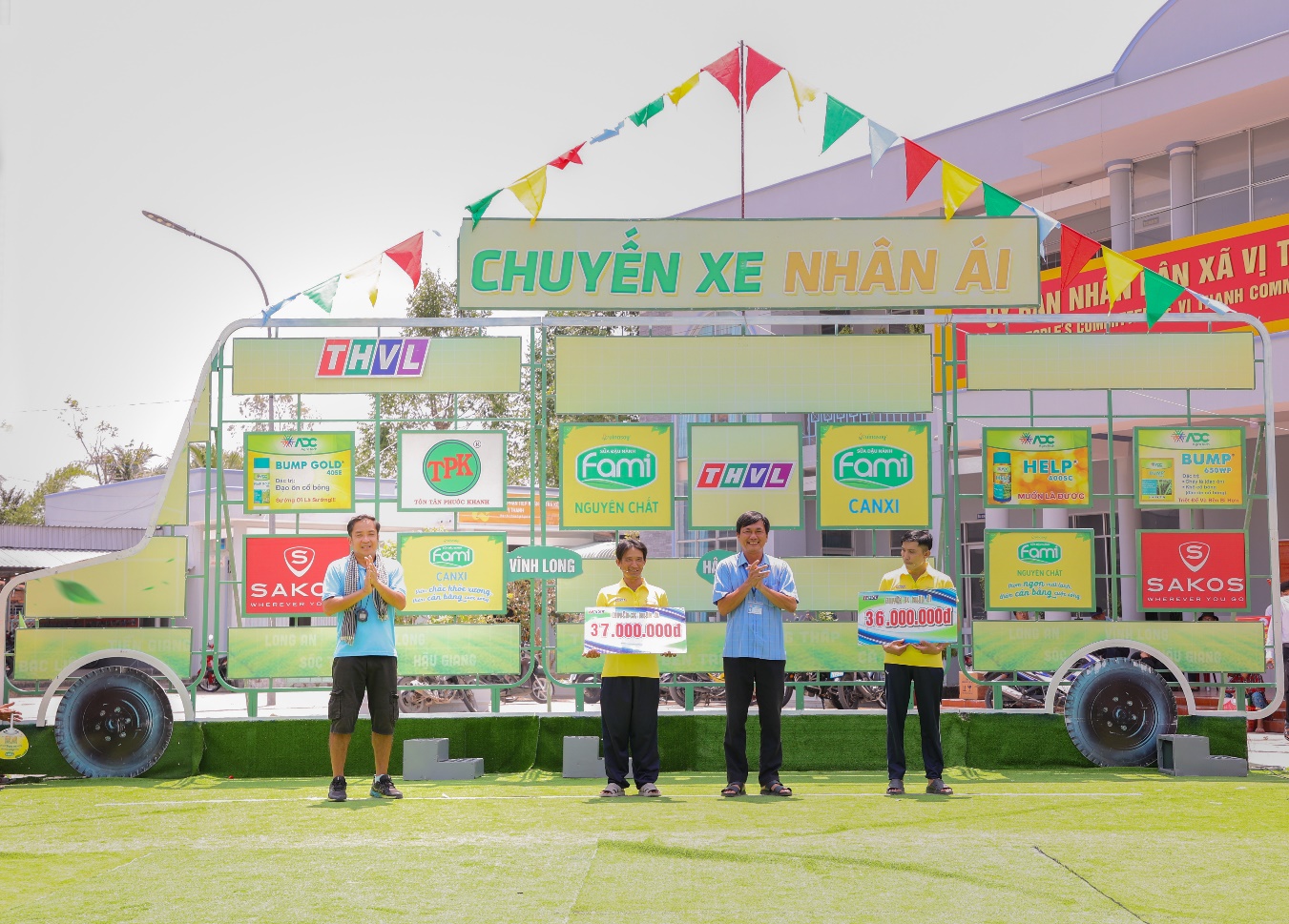 A group of people standing in front of a sign  Description automatically generated