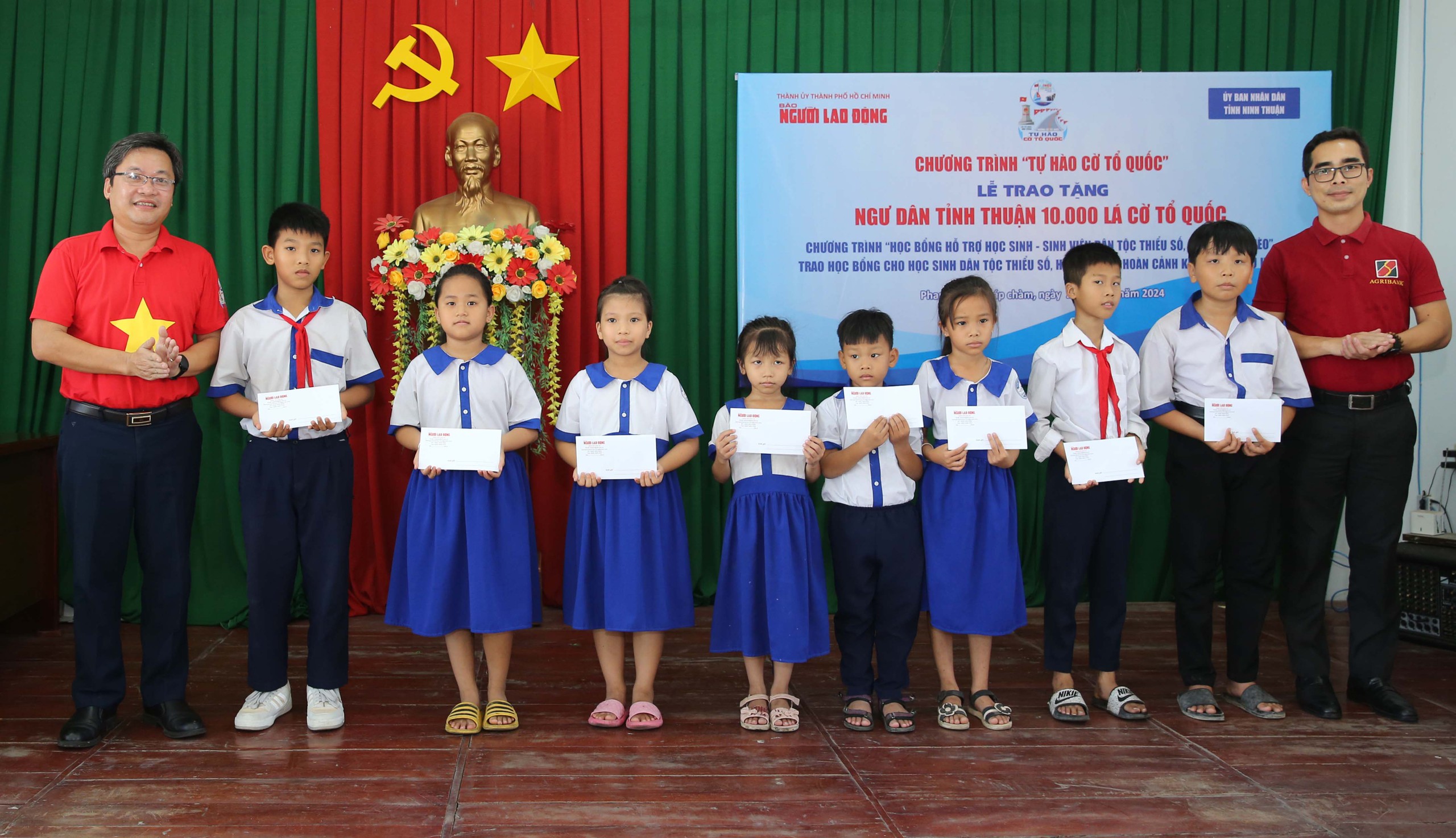 Ông Lê Cao Cường - Phó Tổng Biên tập Báo Người Lao Động (bìa trái) - cùng đại diện Agribank trao học bổng cho con ngư dân nghèo, học sinh dân tộc thiểu số tỉnh Ninh Thuận.Ảnh: HOÀNG TRIỀU