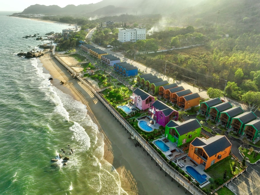 A beach with houses and a body of water Description automatically generated
