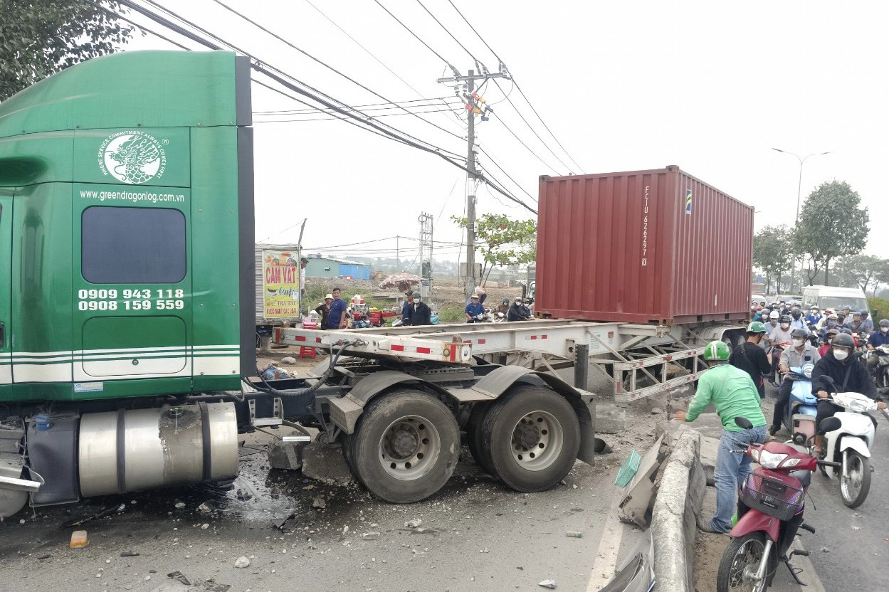 Container ủi dải phân cách, lao vào 3 người trên xe máy- Ảnh 1.