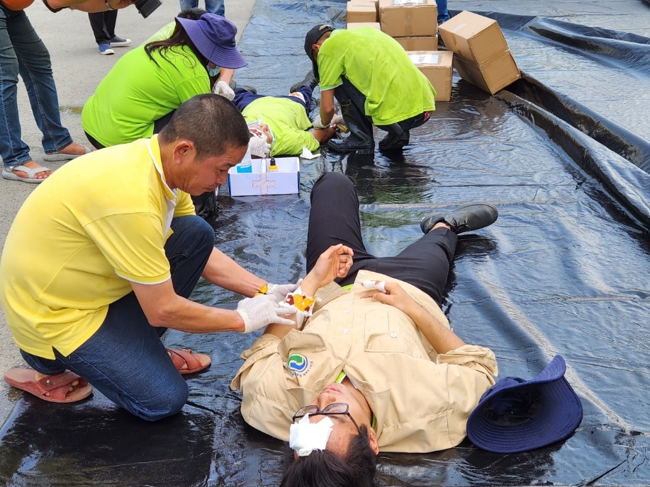 Q:\ChuyenDe\8-4\Ở phía bên ngoài tổ cứu thương tổ chức sơ, cấp cứu cho các công nhân.jpg
