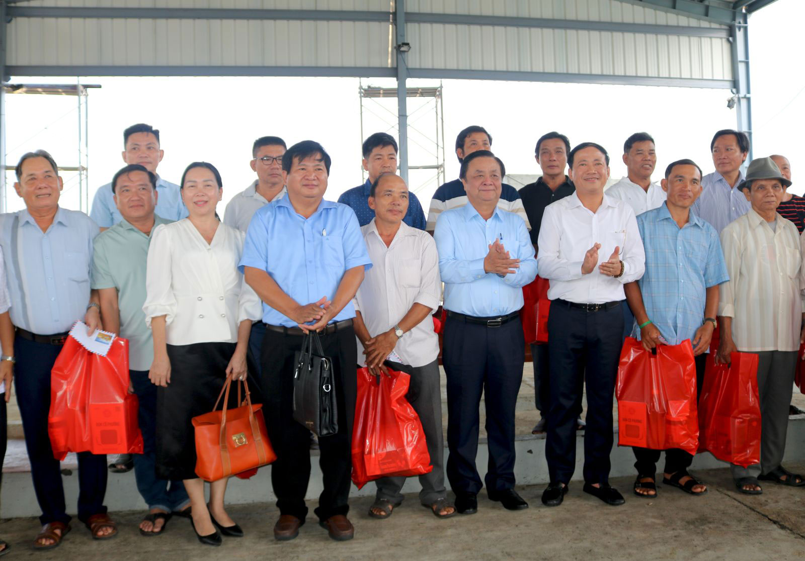 Bộ trưởng L&ecirc; Minh Hoan v&agrave; Chủ tịch UBND tỉnh B&igrave;nh Định Phạm Anh Tuấn (h&agrave;ng đầu, thứ 4 v&agrave; thứ 5 từ tr&aacute;i sang) tặng qu&agrave; cho c&aacute;c ngư d&acirc;n nh&acirc;n chuyến thị s&aacute;t tại cảng c&aacute; Đề Gi