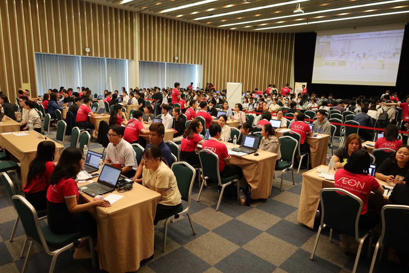 A group of people sitting at tables in a room Description automatically generated