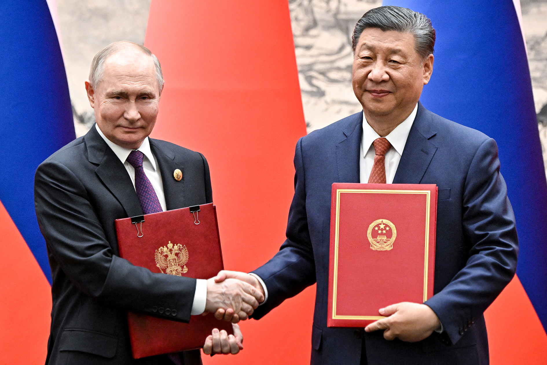 Chủ tịch Trung Quốc Tập Cận Bình và Tổng thống Nga Vladimir Putin trao đổi văn kiện tại cuộc gặp ở thủ đô Bắc Kinh hôm 16-5 Ảnh: REUTERS