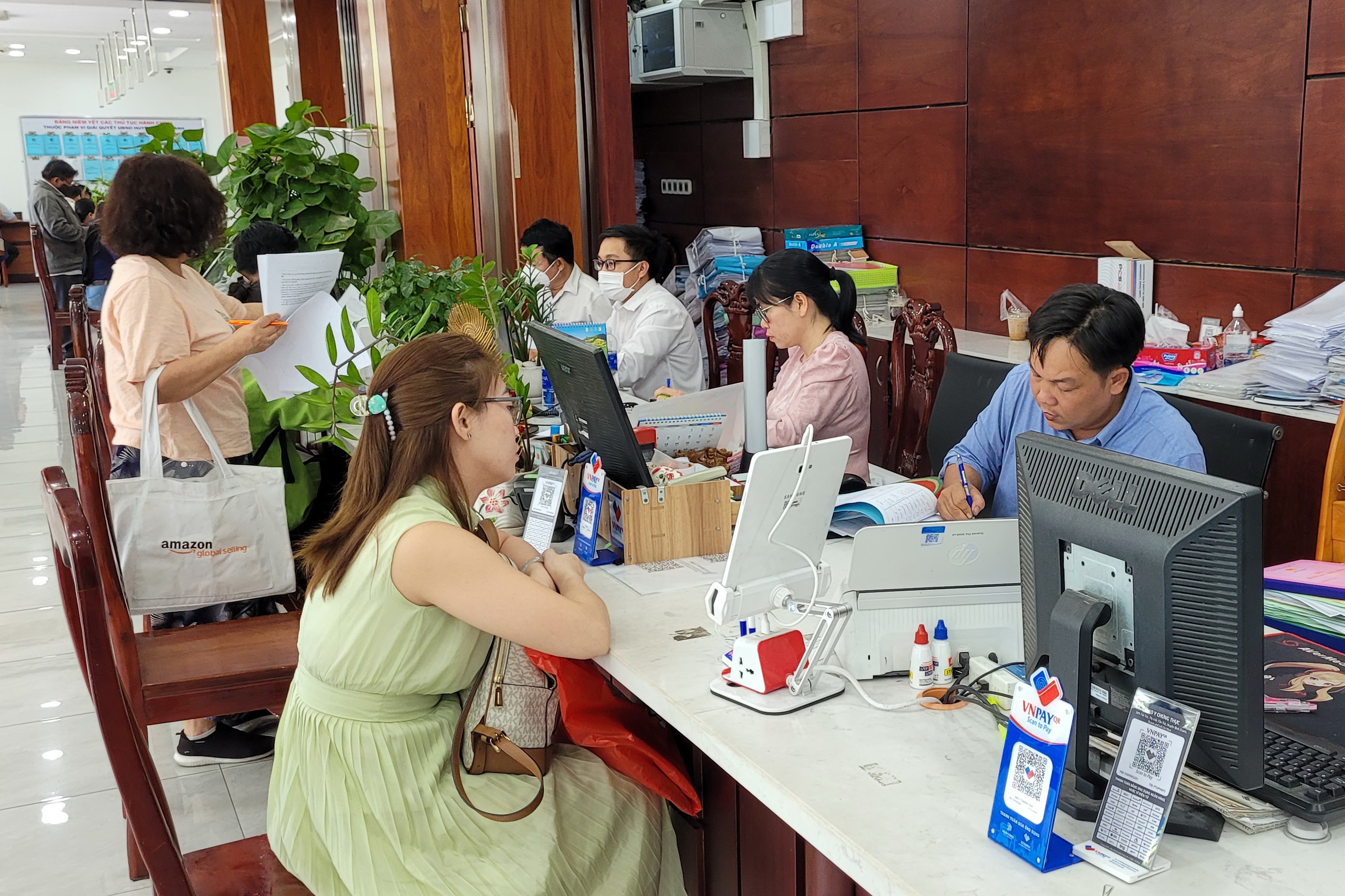 Tiền lương của công chức, viên chức dự kiến tăng 30% từ ngày 1-7-2024. Trong ảnh: Cán bộ, công chức UBND huyện Bình Chánh, TP HCM giải quyết thủ tục hành chính cho người dân.Ảnh: TẤN THẠNH