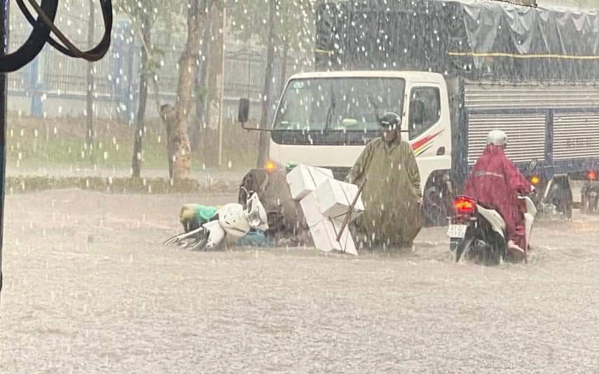 Mưa trắng trời, người và xe té ngã trong nước ngập