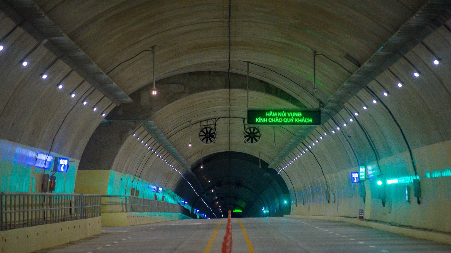 A tunnel with lights and signs Description automatically generated