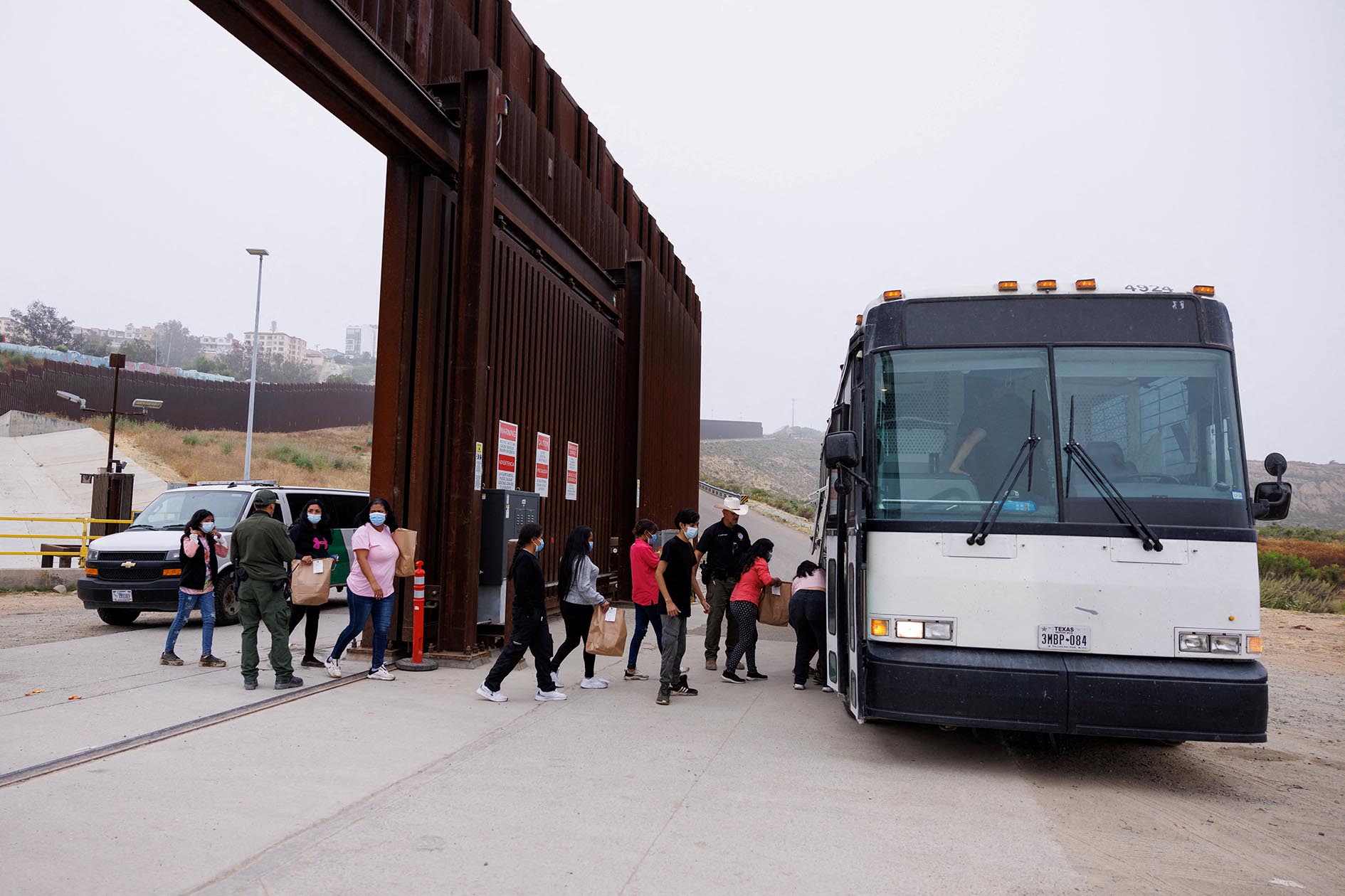 Người nhập cư được đưa l&ecirc;n xe tại TP San Diego, bang California - Mỹ h&ocirc;m 6-6Ảnh: Reuters