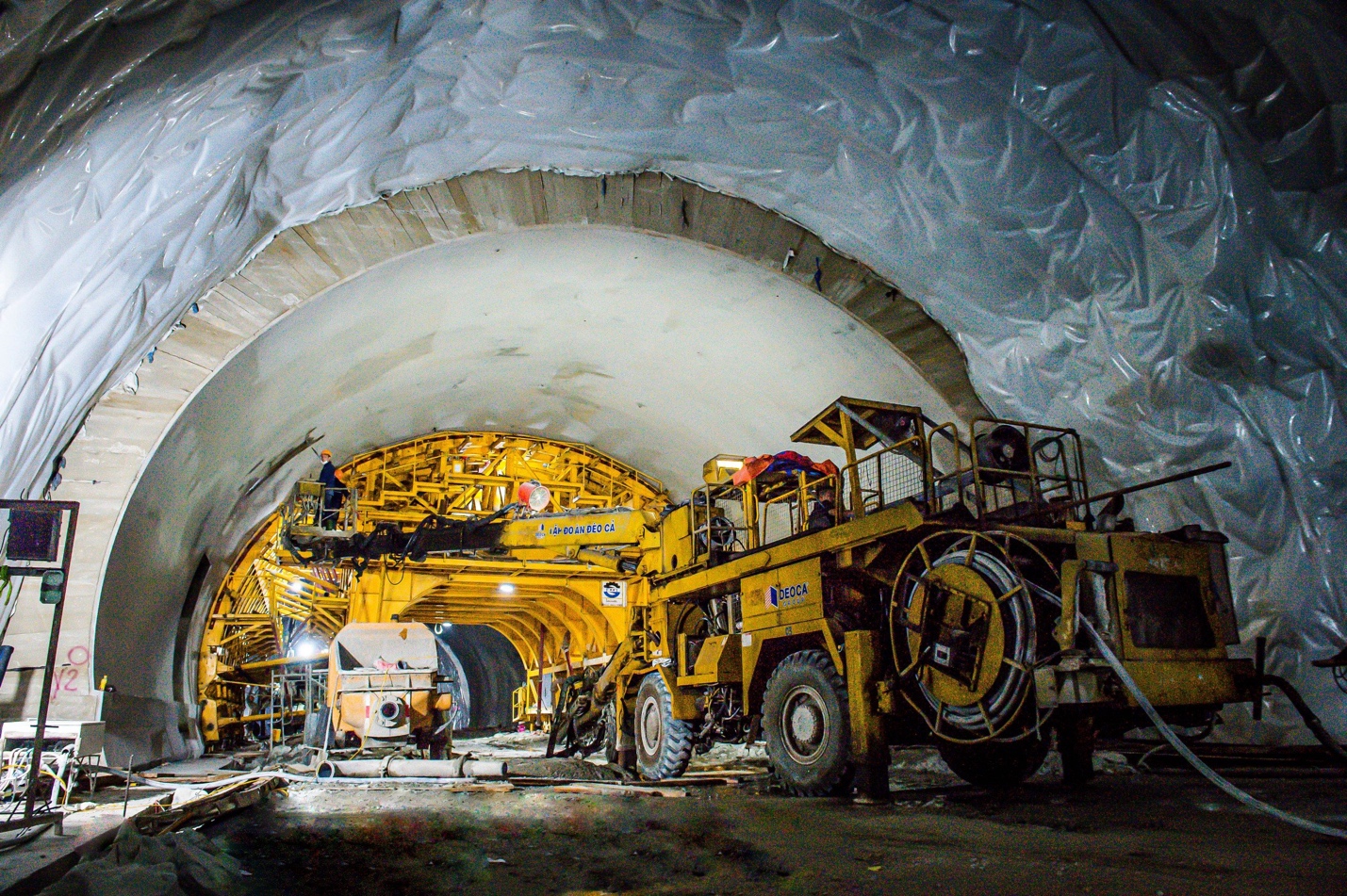 A large yellow vehicle inside a tunnel Description automatically generated
