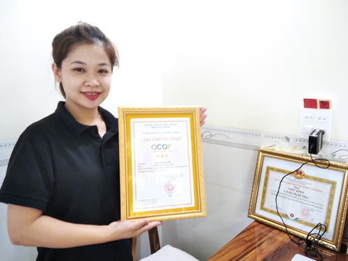 Chị Trần Thị B&eacute; Th&ugrave;y với chứng nhận sản phẩm chả c&aacute; th&aacute;t l&aacute;t cườm Dota Food đạt OCOP 3 sao