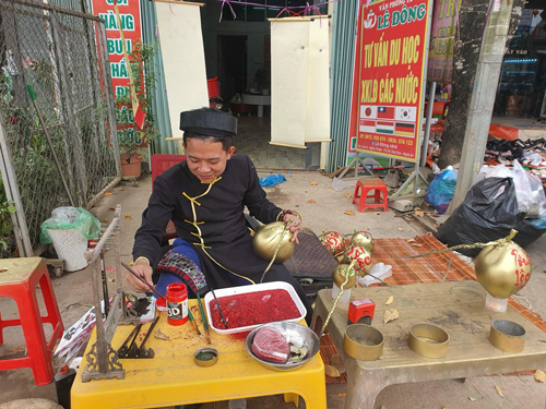 Anh Lê Văn Đông viết thư pháp lên trái dừa