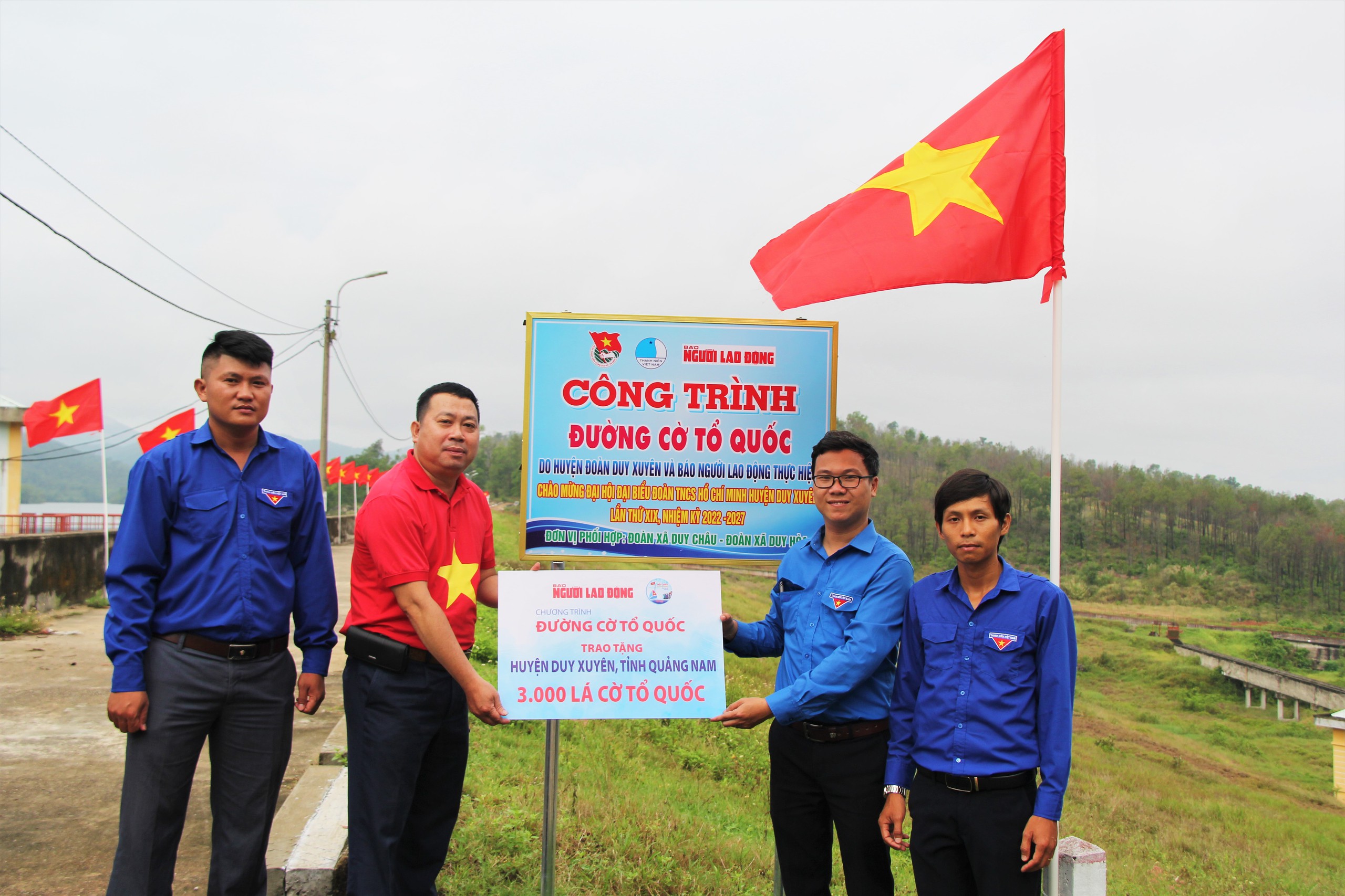 Nhà báo Đặng Hoàng Dũng (thứ hai từ trái qua) trao cờ Tổ quốc cho Huyện Đoàn Duy Xuyên, tỉnh Quảng Nam để thực hiện những “Đường cờ Tổ quốc” ở huyện nàyẢnh: TRẦN THƯỜNG