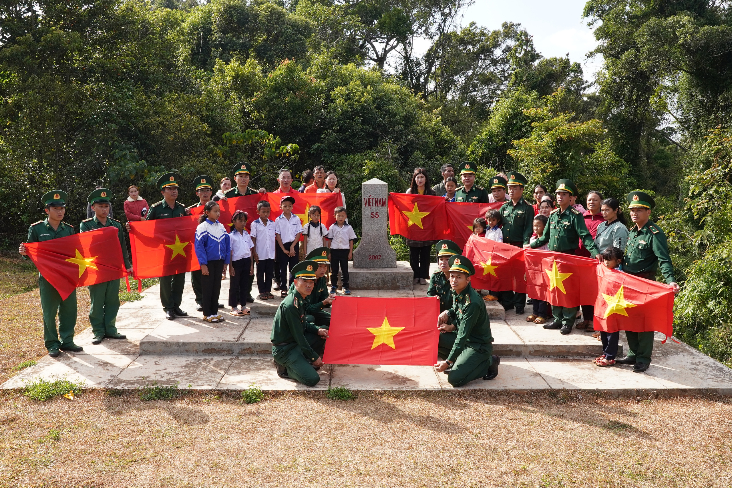 Cán bộ, chiến sĩ Đồn Biên phòng Tuy Đức và lãnh đạo tỉnh Đắk Nông cùng người dân và Đoàn công tác Báo Người Lao Động chào cờ tại cột mốc số 55 Ảnh: QUANG LIÊM
