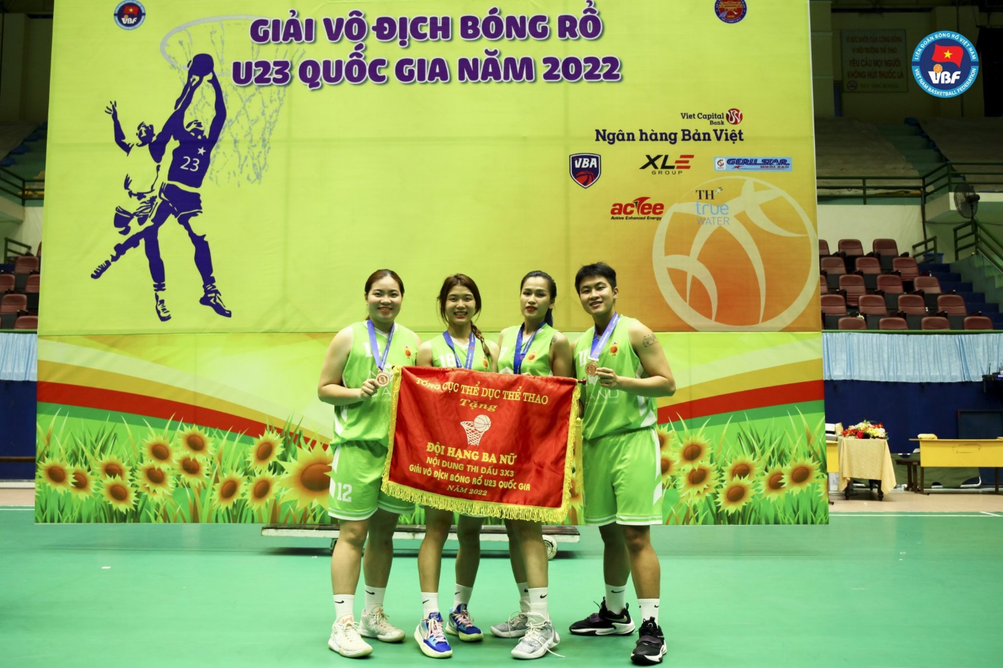 A group of people holding a banner Description automatically generated