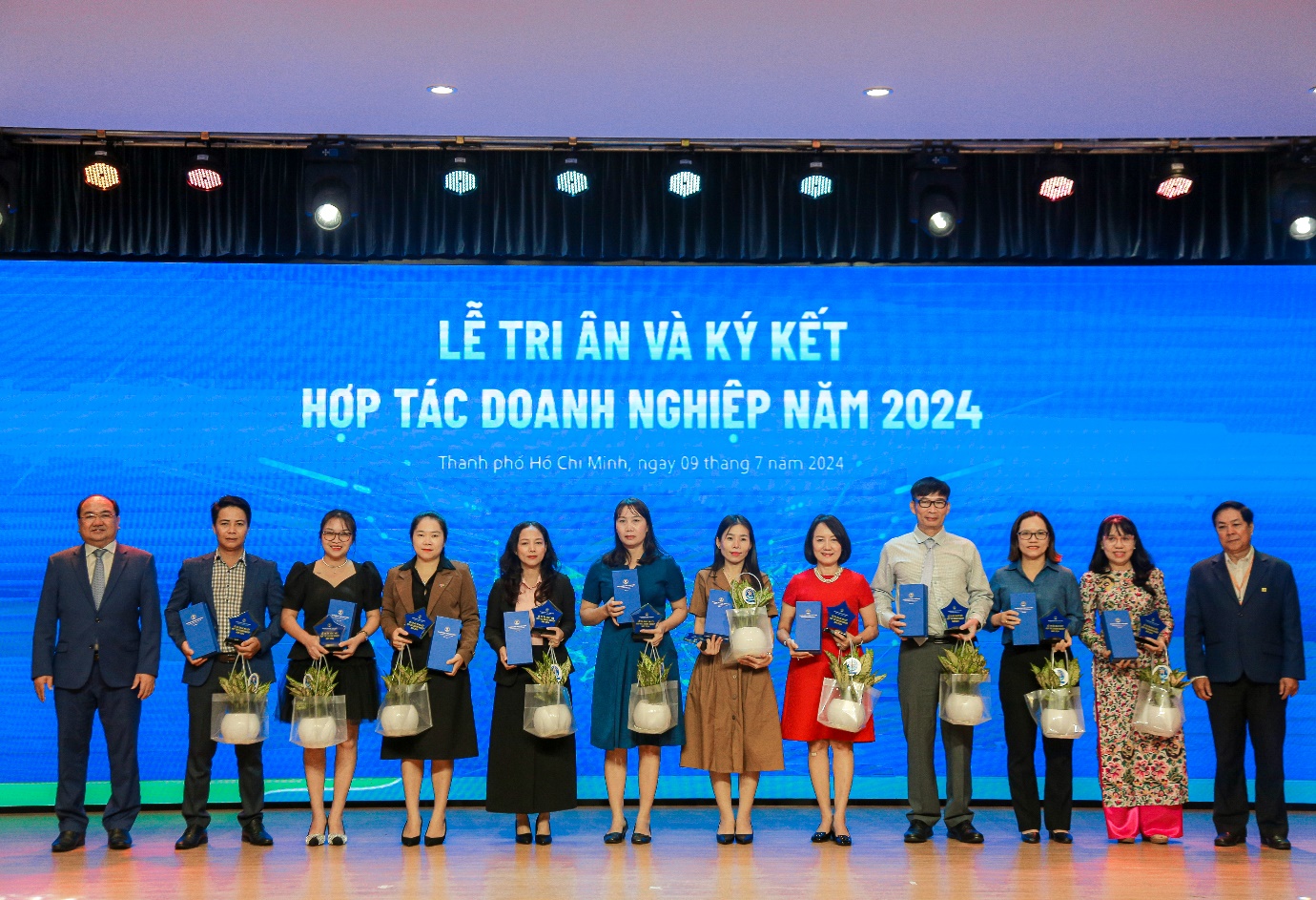 A group of people holding awards Description automatically generated