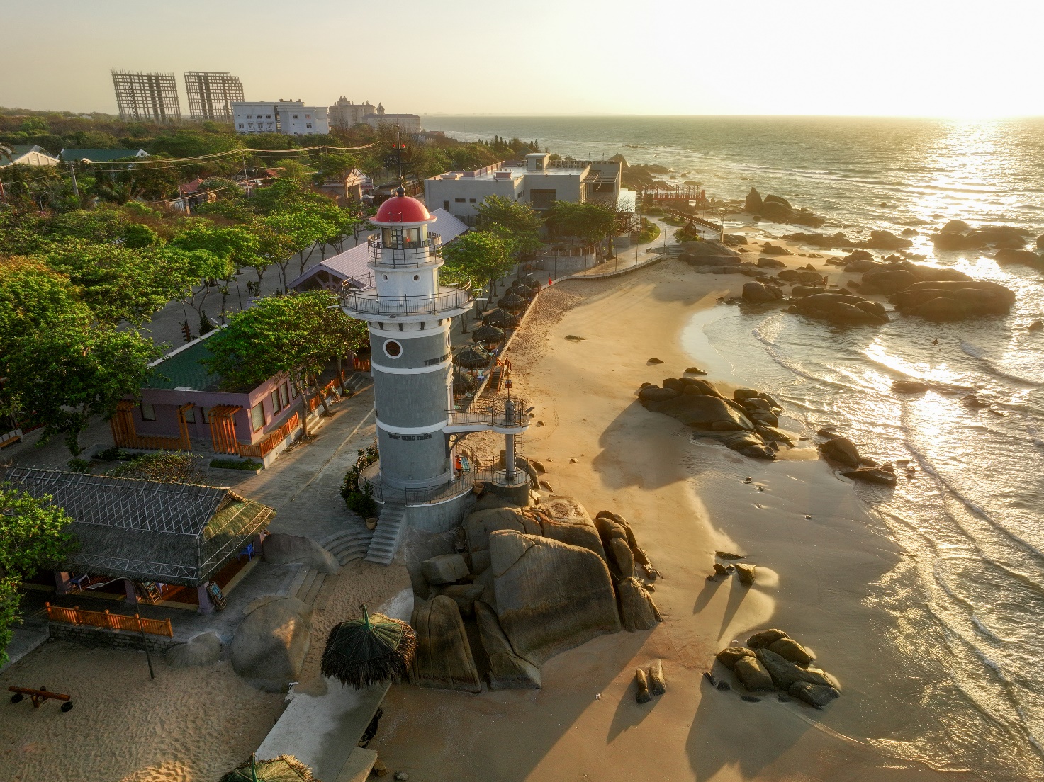 A lighthouse on a beach Description automatically generated