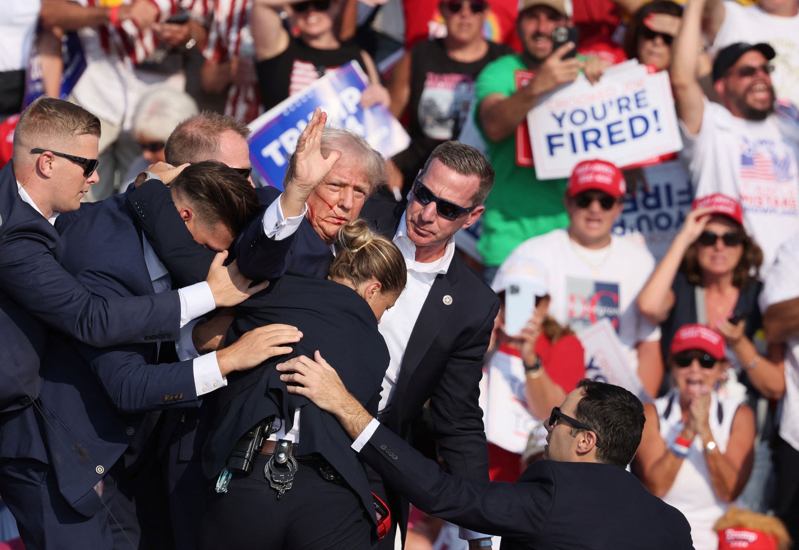 Cựu Tổng thống Donald Trump được nh&acirc;n vi&ecirc;n Sở Mật vụ che chắn, hộ tống sau vụ nổ s&uacute;ng ở TP Butler, bang Pennsylvania - Mỹ Ảnh: REUTERS