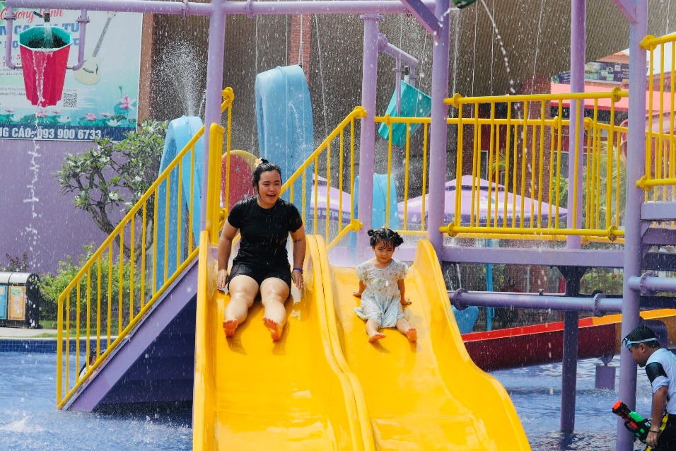 A person and child on a water slide Description automatically generated