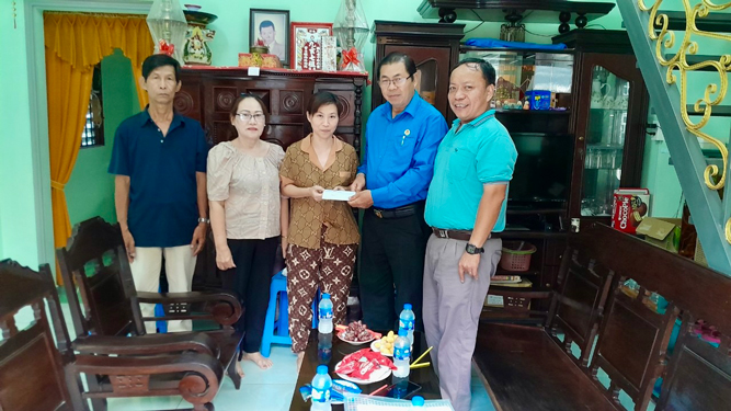 Ông Nguyễn Ngọc Tráng (bìa phải), Chủ tịch Công đoàn Công ty CP Sản xuất Kinh doanh Sơn Kim, trao hỗ trợ cho đoàn viên - lao động khó khăn Ảnh: HUỲNH NHƯ
