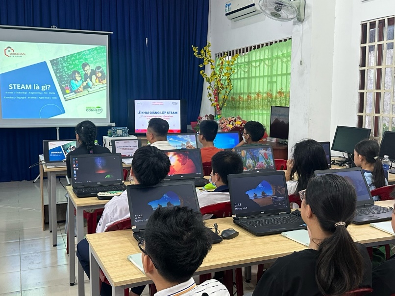 A group of people in a classroom with laptops  Description automatically generated
