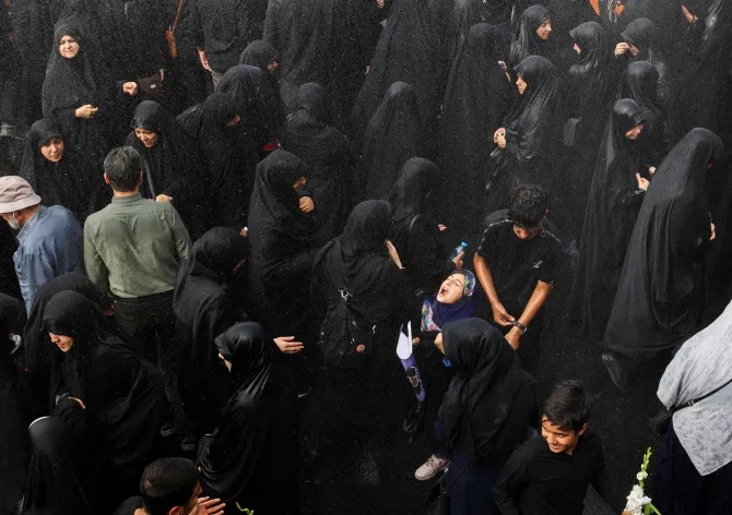 Một c&ocirc; g&aacute;i giữa trời mưa trong đ&aacute;m tang ở Tehran. Ảnh: Reuters
