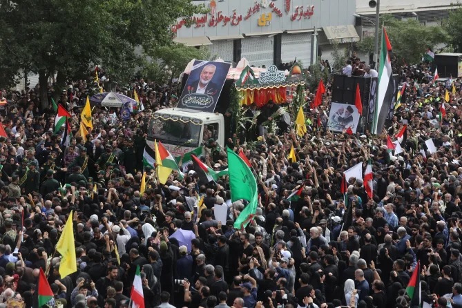 Xe chở linh cữu thủ lĩnh Hamas v&agrave; vệ sĩ của &ocirc;ng đi qua đ&aacute;m đ&ocirc;ng ở Tehran. Ảnh: Reuters
