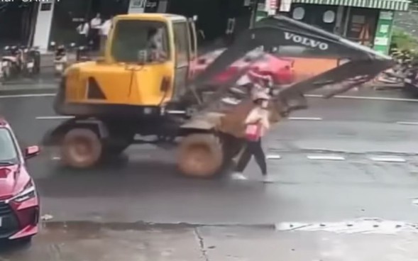 VIDEO: Đi bộ dưới l&ograve;ng đường, người phụ nữ bị m&aacute;y x&uacute;c c&aacute;n qua người
