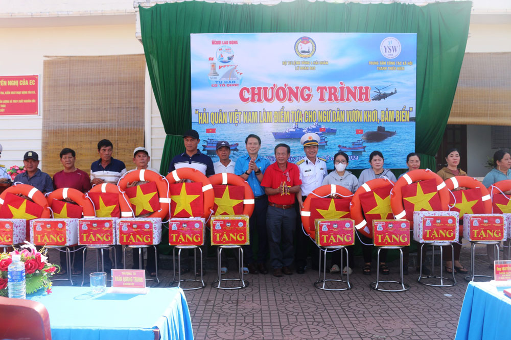 Đại diện Báo Người Lao Động và Lữ đoàn 682 Vùng 4 Hải quân trao cờ Tổ quốc và quà cho ngư dân Phú Yên. Ảnh: THÙY DUNG