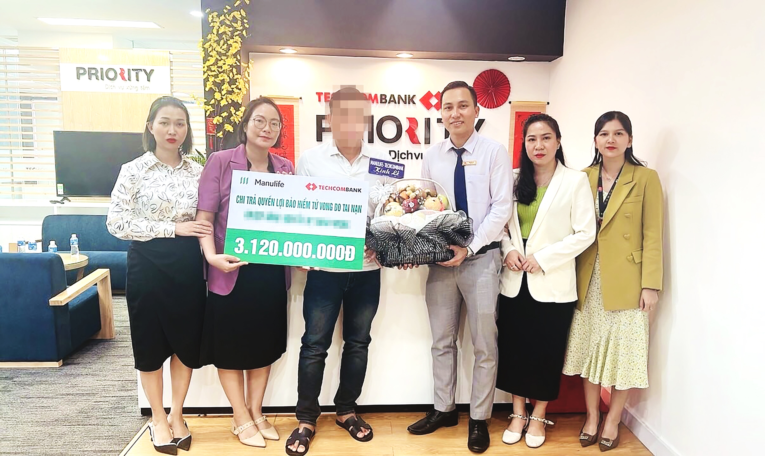 Đại diện gia đ&igrave;nh của kh&aacute;ch h&agrave;ng nhận số tiền chi trả quyền lợi bảo hiểm từ Manulife Việt Nam v&agrave; Techcombank