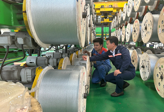 Anh Nguyễn Th&agrave;nh Long (b&ecirc;n phải) hướng dẫn đồng nghiệp kiểm tra sợi c&aacute;p trong băng tải l&otilde;i th&eacute;p